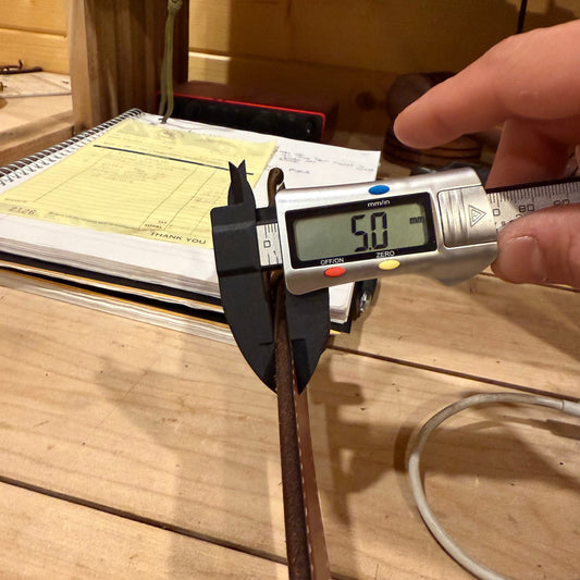 mens leather belt getting measured with calipers